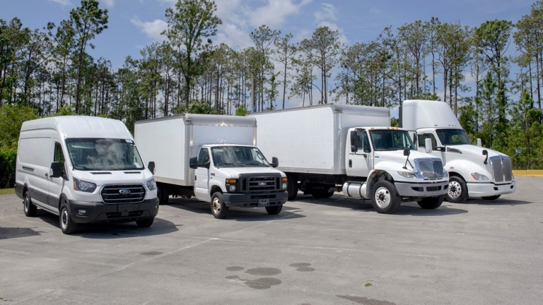 Work vans and box trucks lined up on an FLD lot