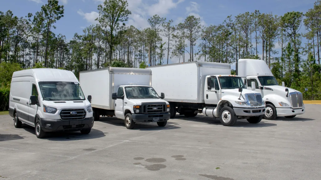 fleet vehicle disposal services Ford work vans and box trucks lined up on a lot